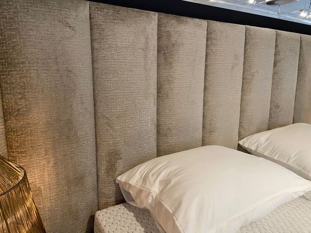 Boxspring met gestoffeerd velours hoofdbord en witte kussens
